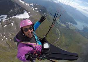 Åsmund Rognerud Birkeland henger høyt i en paraglider, over fjell og fjord