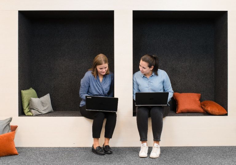 To sittende kvinner med PCer